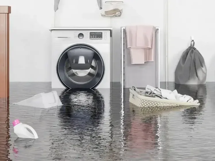 Laundry room floor under water around a washer after its supply hose gave out